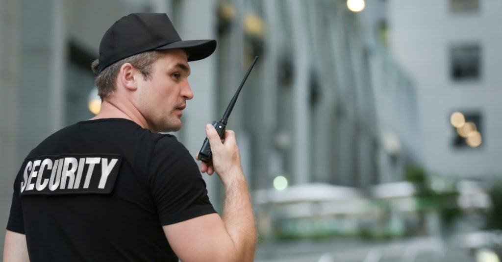 Man met security op zijn shirt praat via walkie talkie met museum beveiligers voor object beveiliging